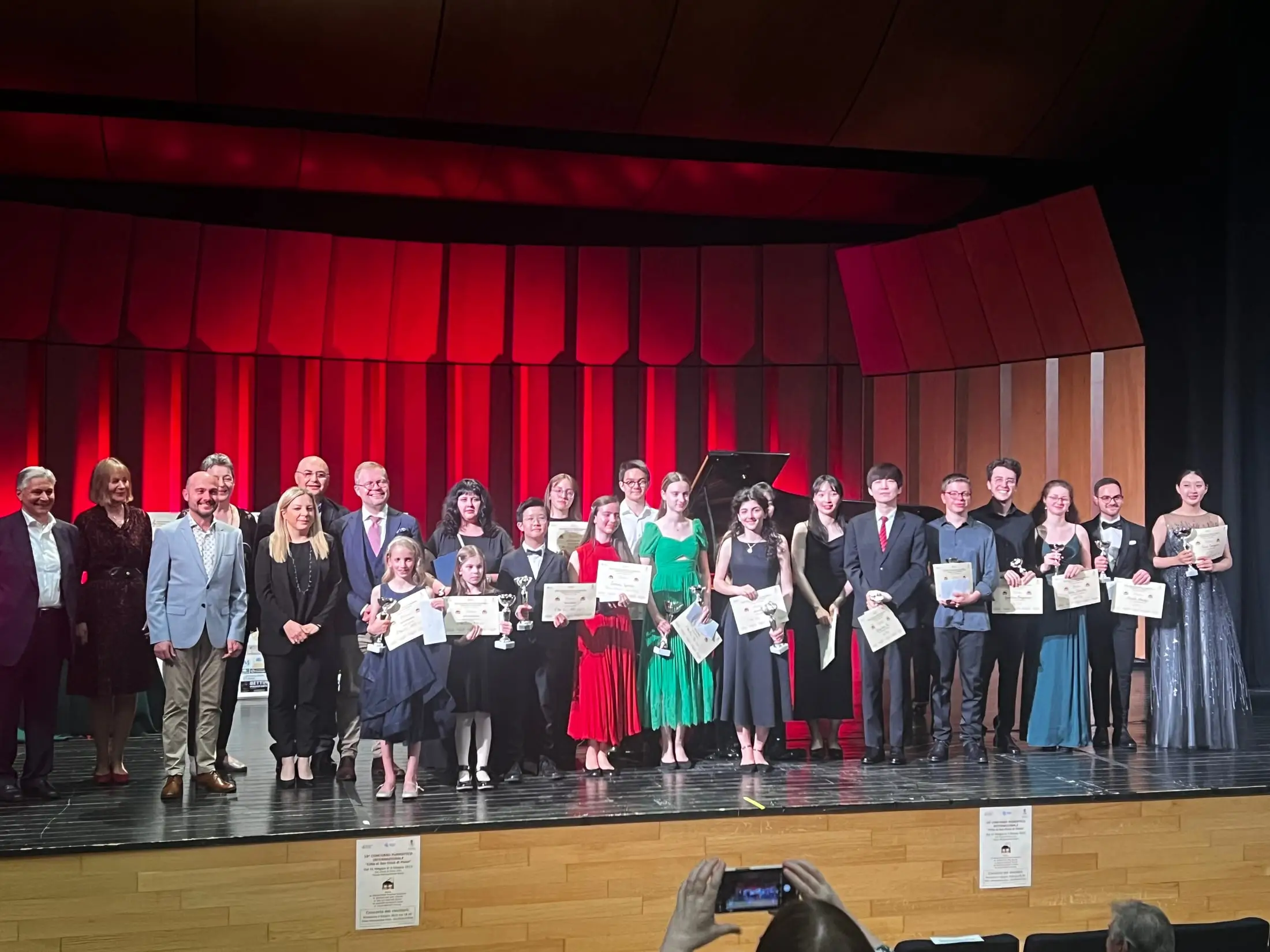A group of students on stage holding certificates at prize-giving