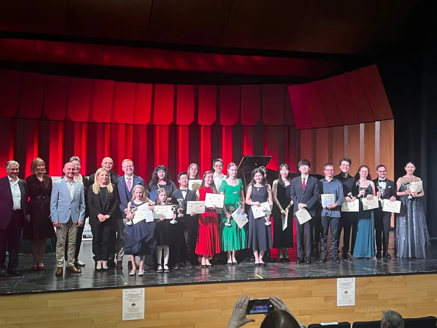 A group of students on stage holding certificates at prize-giving